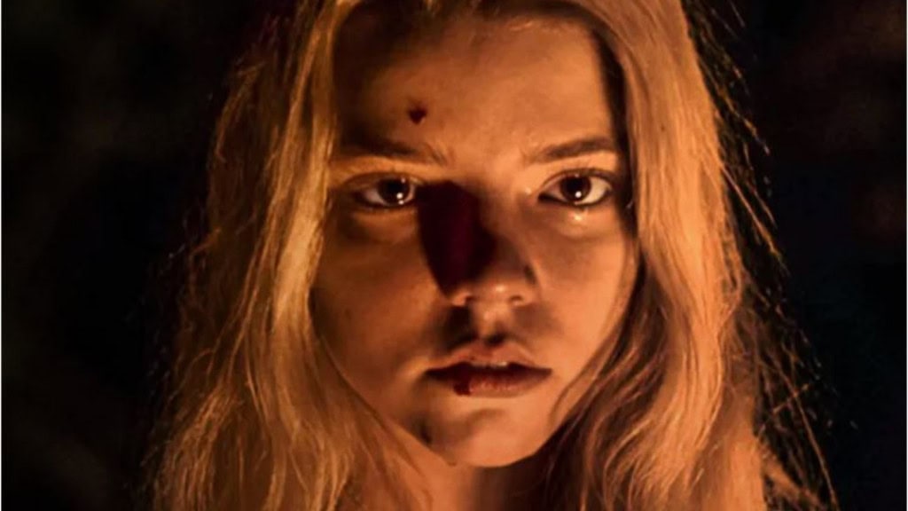 menina loira com pinta na teste em meio a uma luz que reflete em seu rosto no escuro