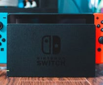 Console Nintendo Switch na base sobre mesa de madeira