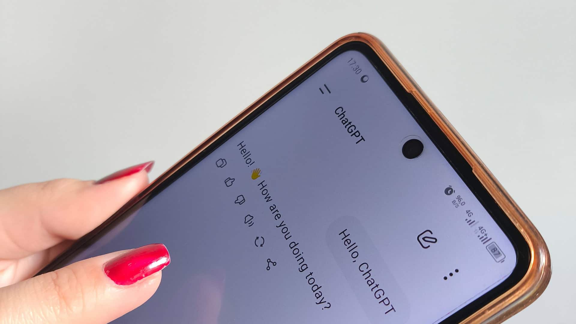 mão feminina com unhas pintadas de vermelho, segurando celular aberto no ChatGPT