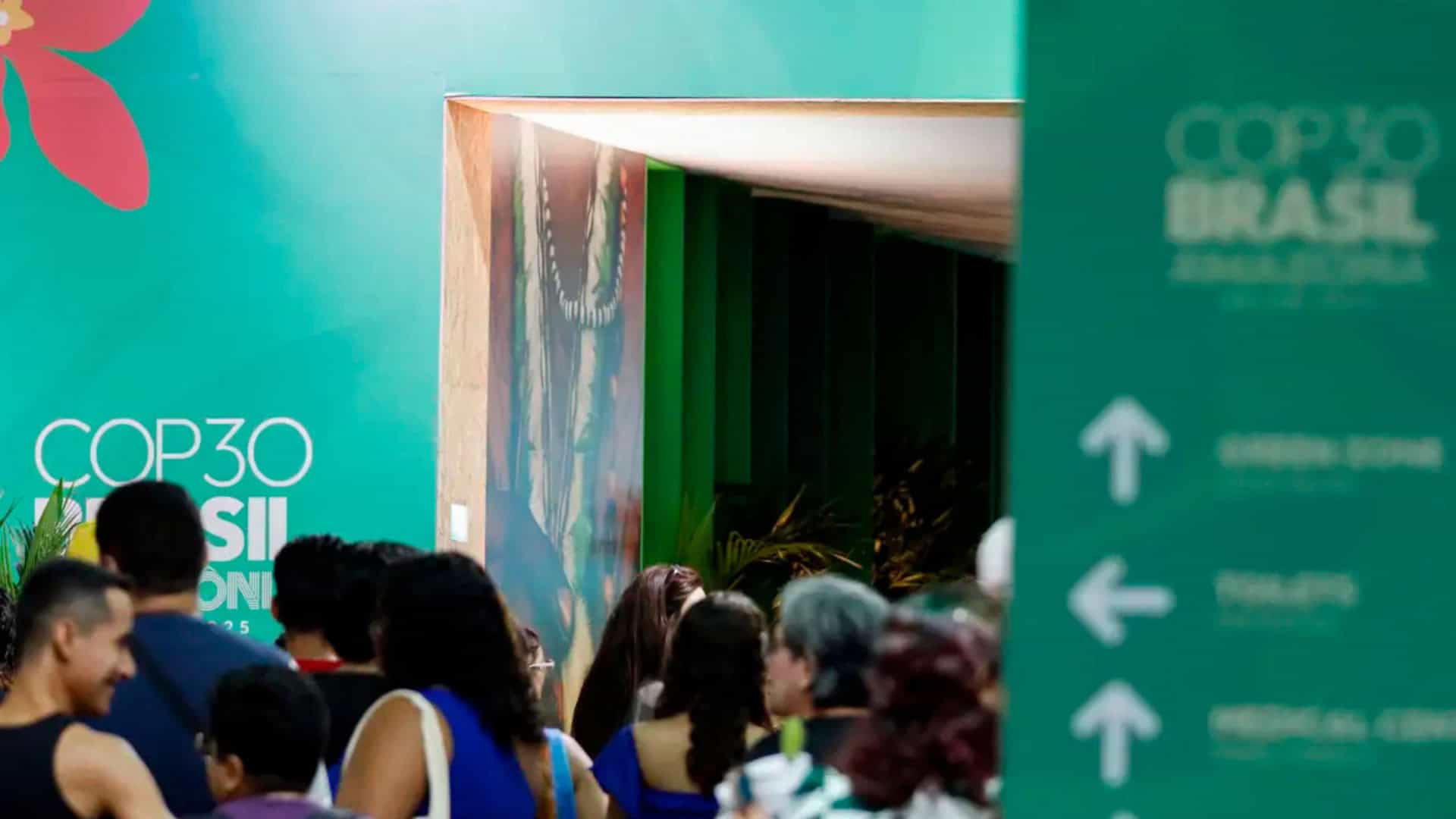 Placa, corredor e gente na COP30, em Belém