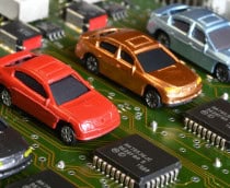 Miniaturas de carros colocadas ao lado de chips em placa de computador
