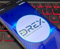 Celular com logomarca do Drex na tela colocado em cima de teclado de notebook