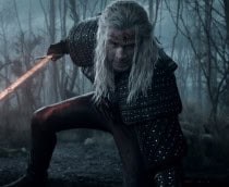 Liam Hemsworth ajoelhado com uma espada na mão em cena de Thw Witcher