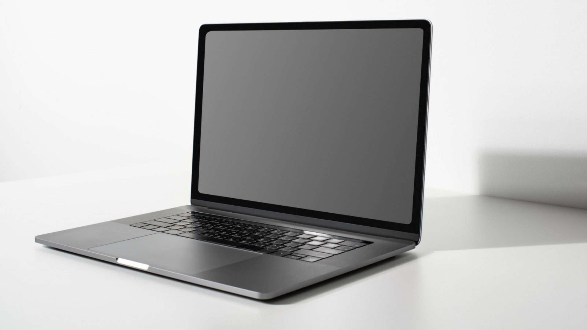 Laptop com tela preta em branco em uma mesa branca