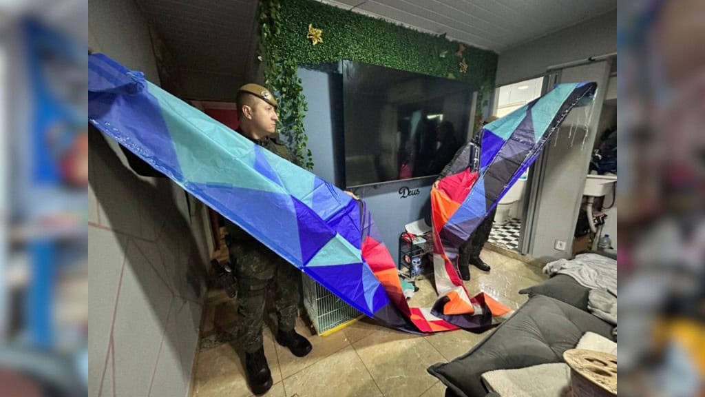 Policial segurando um dos balões apreendidos na Operação Bancada