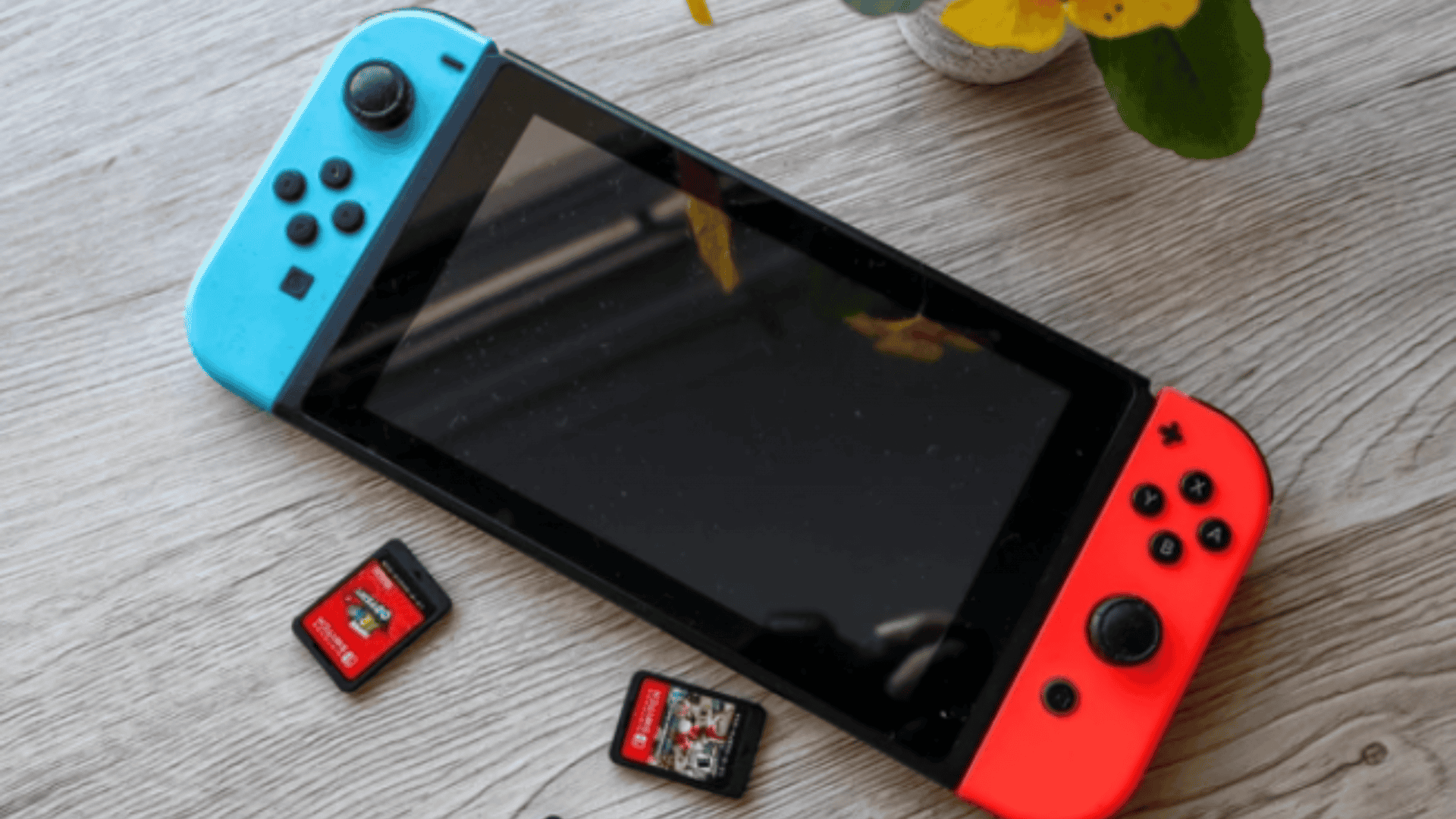 foto de um console nintendo switch em cima de uma mesa de madeira