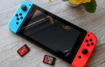 foto de um console nintendo switch em cima de uma mesa de madeira