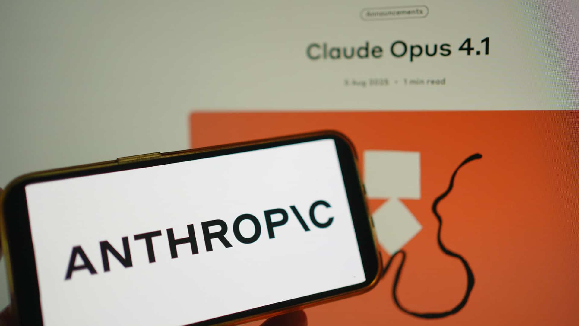 Logo da Anthropic em um smartphone na horizontal ao lado da página web do Claude Opus