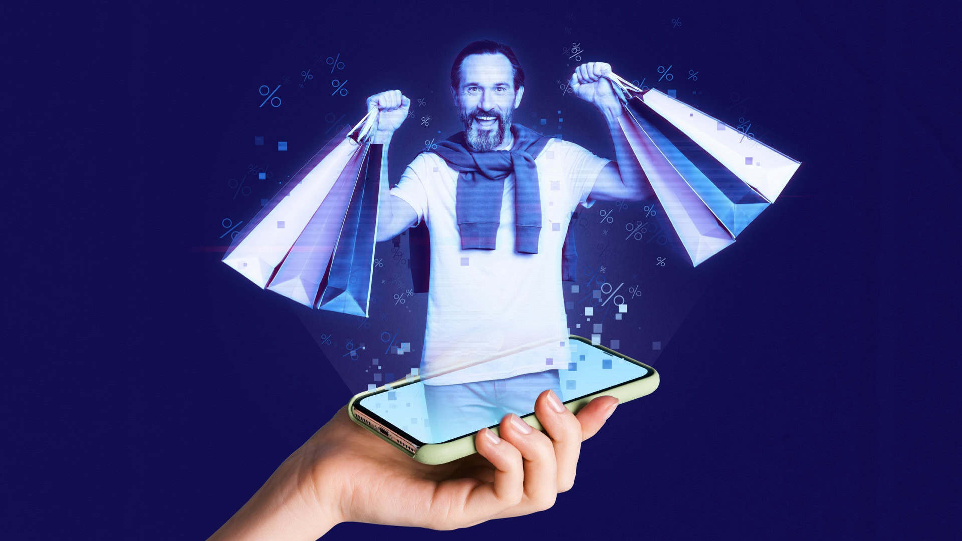 Braço de uma pessoa segurando um celular do qual está sendo projetado, para fora, um homem sorrindo e erguendo várias sacolas com as duas mãos