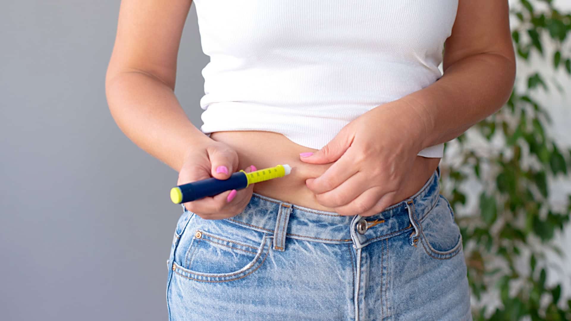 Mulher aplicando caneta emagrecedora na barriga