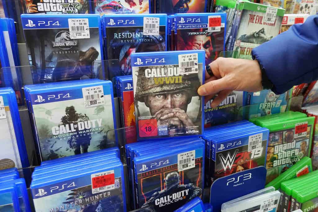 Um homem escolhe um jogo físico em uma loja