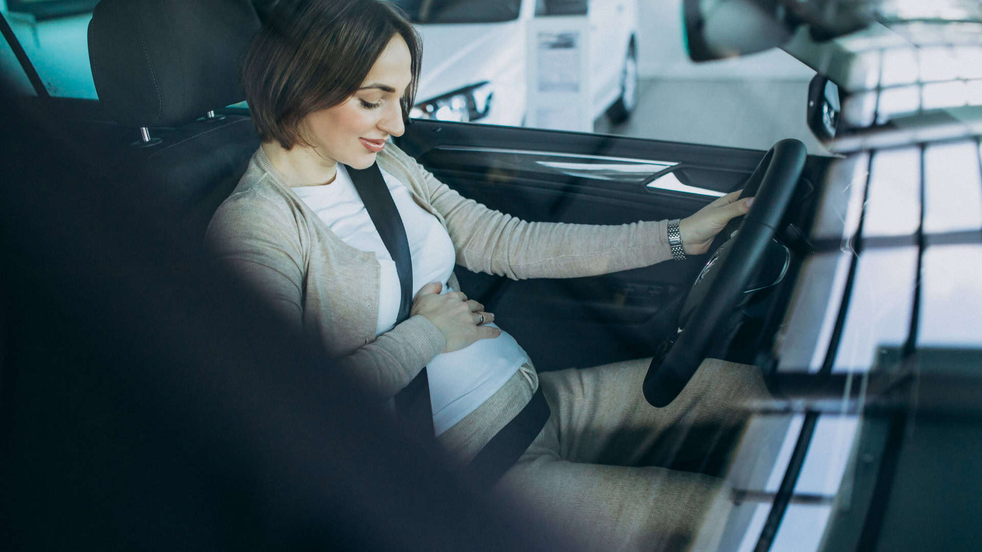 Gestante testando um carro numa loja de automóveis