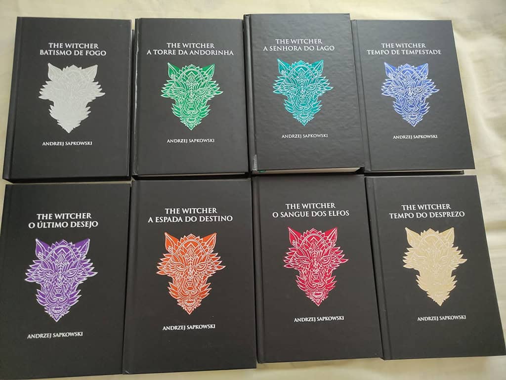 Conjunto de oito livros da saga The Witcher, de Andrzej Sapkowski, com capas duras pretas e ilustrações coloridas de cabeças de lobo em cada volume