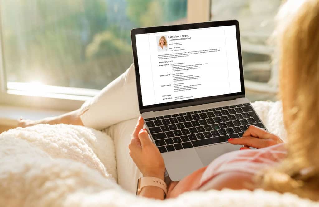 Mulher cria currículo em editor de texto no notebook