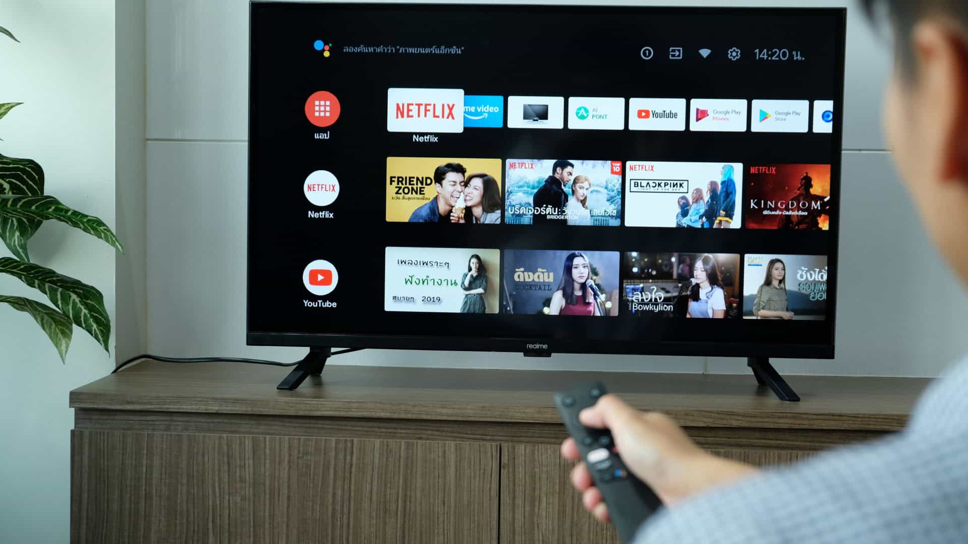 Pessoa usando controle remoto para acessar menu de configurações de Smart TV