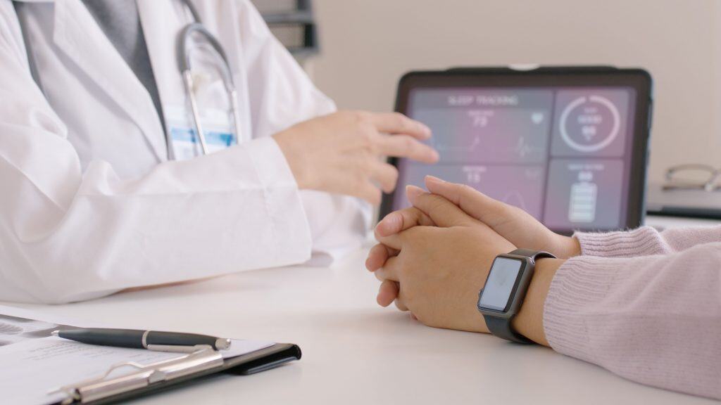 homem um uma consulta medica com um smartwatch no pulso /