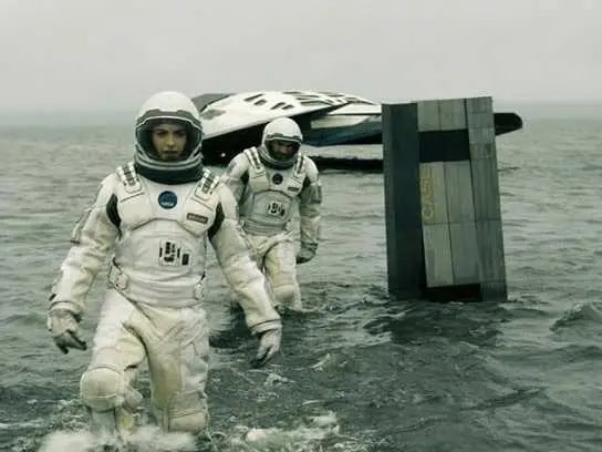 Cena de Interestelar com dois astronautas ao lado do robô Tardis