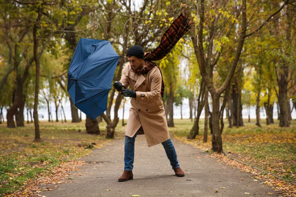 Homem lutando com o guarda-chuva e o vento