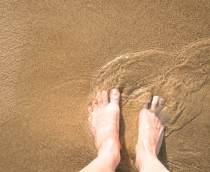 Foto de vista superior de pés na areia molhada