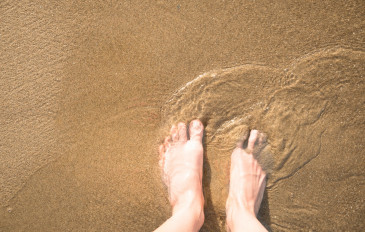 Foto de vista superior de pés na areia molhada