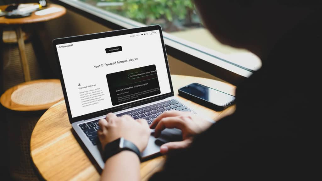 Pessoa usando notebook em ambiente tranquilo, com o site do NotebookLM aberto na tela. Interface mostra opções para resumir conteúdos como PDFs e vídeos, com destaque para o romance Ulisses.