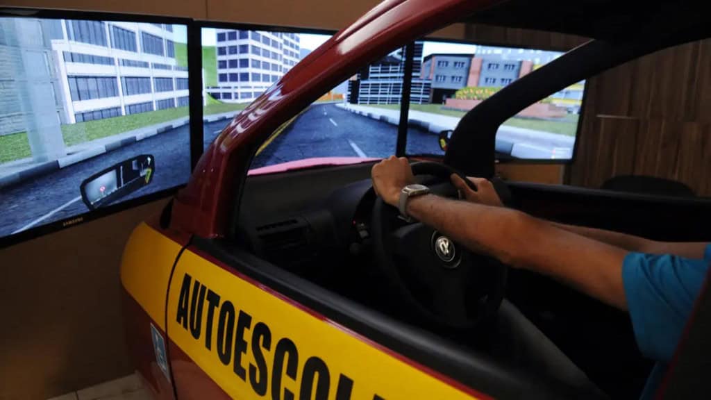 Homem fazendo aula em simulador numa autoescola para tirar CNH