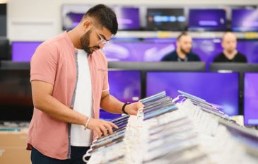 Homem mexendo em celular em loja