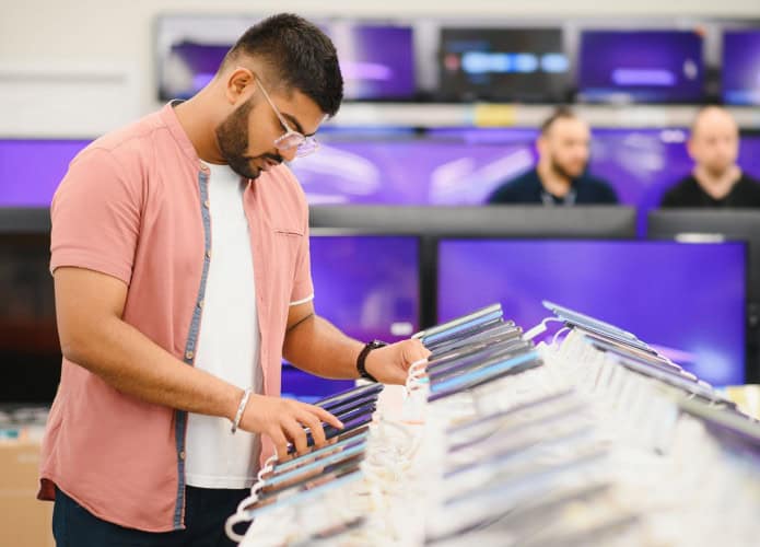 Homem mexendo em celular em loja