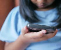 Foto bem de perto de menina usando celular