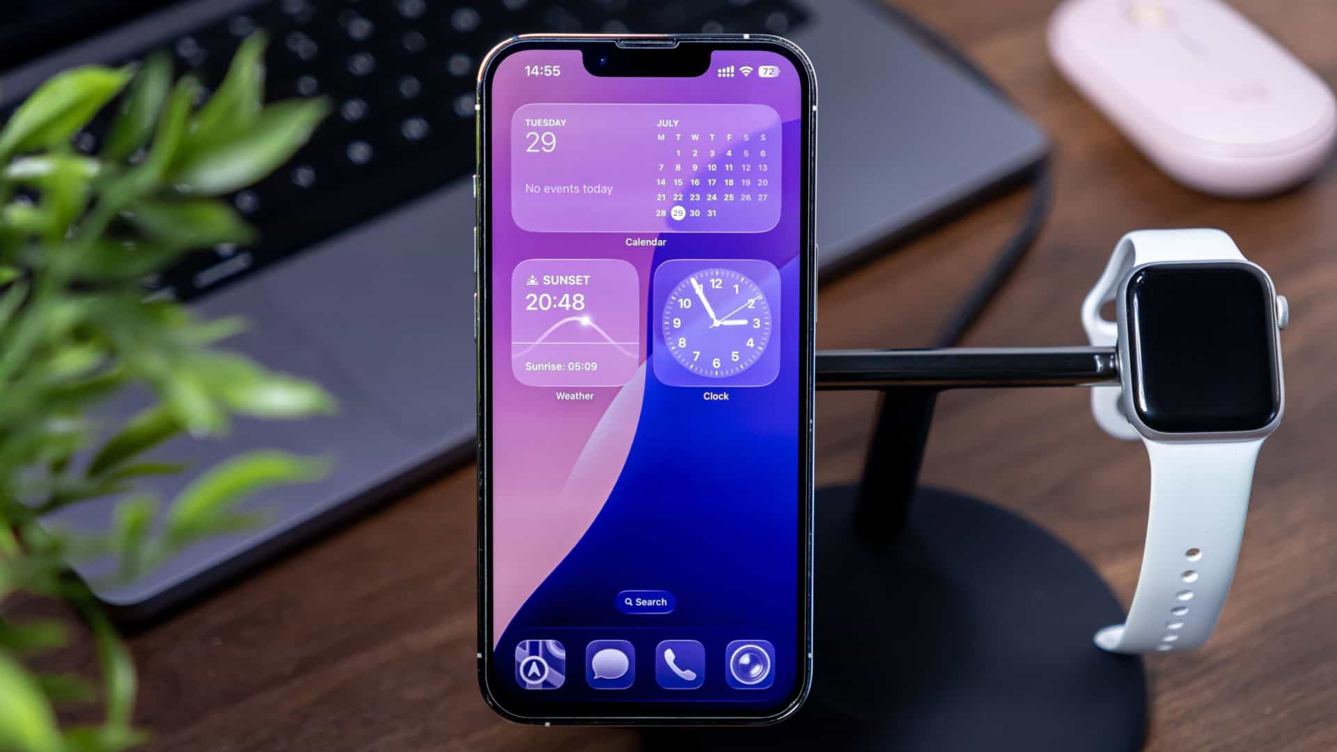 iPhone com iOS 26 instalado colocado num suporte ao lado de um Apple Watch