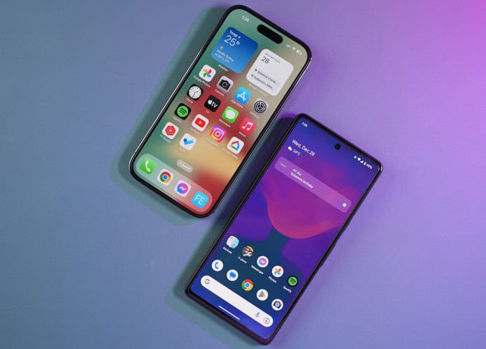 iPhone ao lado de celular Android – ambos colocados sobre uma mesa