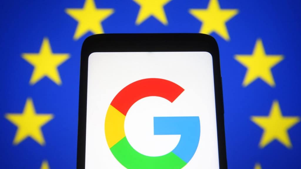 Logotipo do Google em celular com bandeira da União Europeia ao fundo