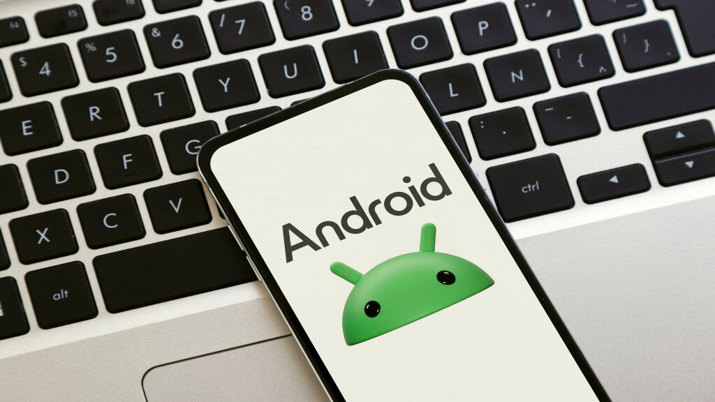Um smartphone sobre um laptop exibindo o novo logotipo do Android