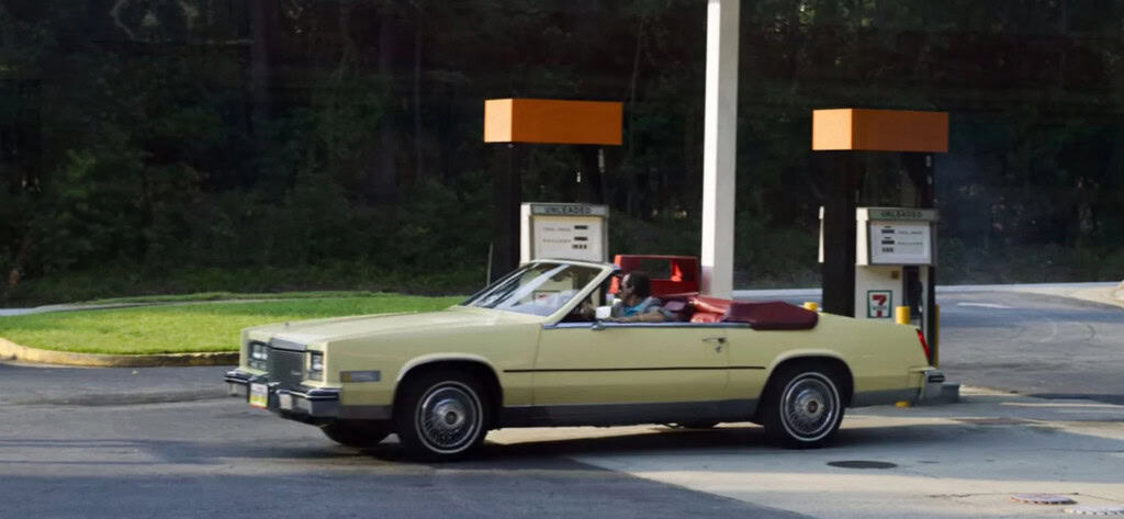 Cena com Cadillac Eldorado de 1984 da terceira temporada, episódio Cinco de Stranger Things. Foto de um Cadillac Eldorado Biarritz 1984 Convertible amarelo-creme estacionado em um posto de gasolina 7-Eleven