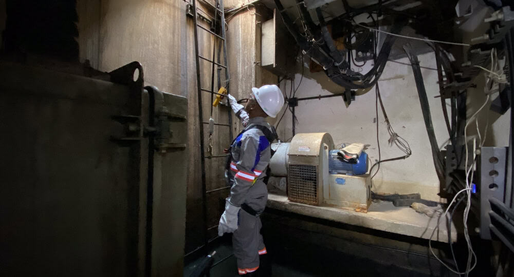 Pessoa olhando para cima próximo a uma escada no subterrâneo