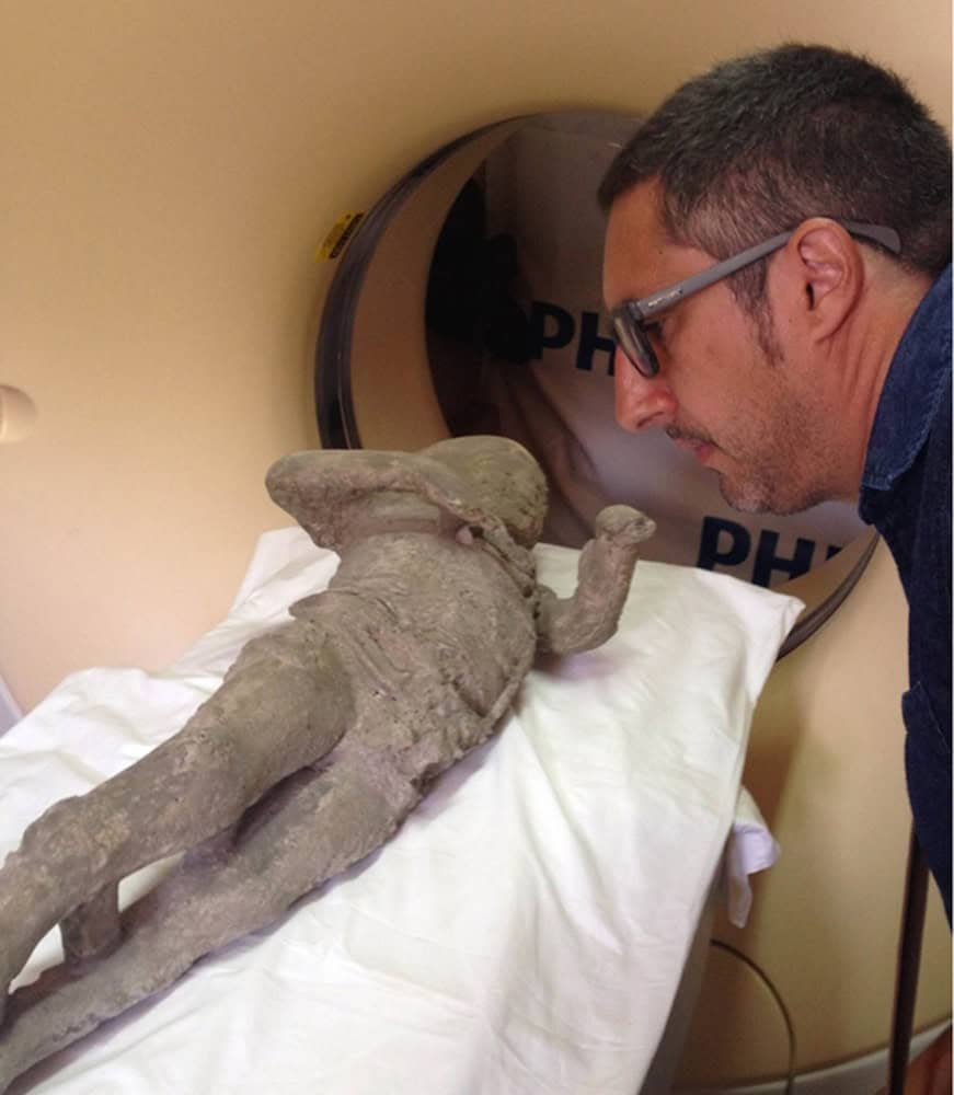 pesquisador analisa moldes de gesso de vítimas de pompeia