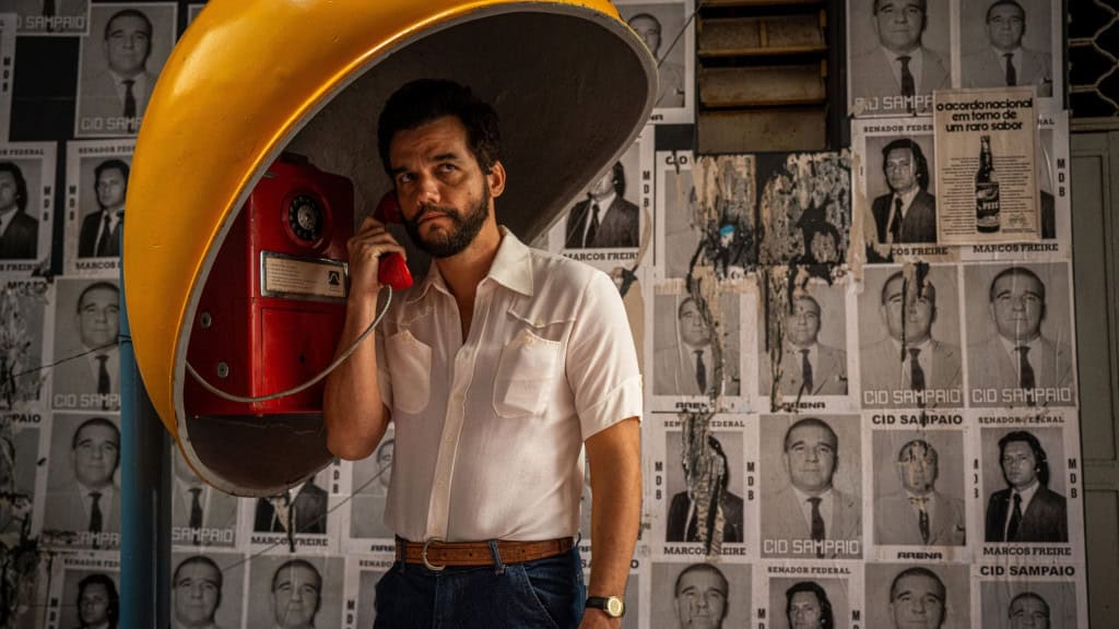 Marcelo, interpretado por Wagner Moura, segurando telefone em orelhão em pôster do filme Agente Secreto