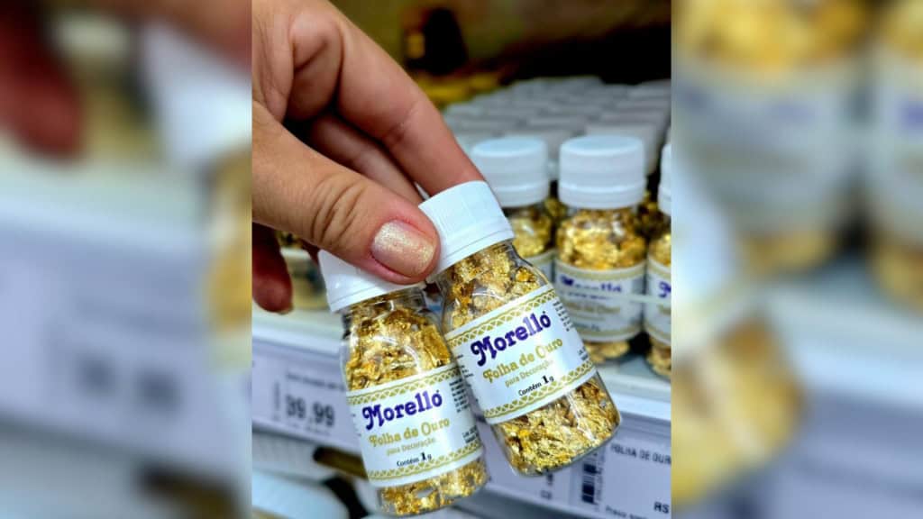 Mulher segurando potinhos com folha de ouro da marca Morello, proibida pela Anvisa