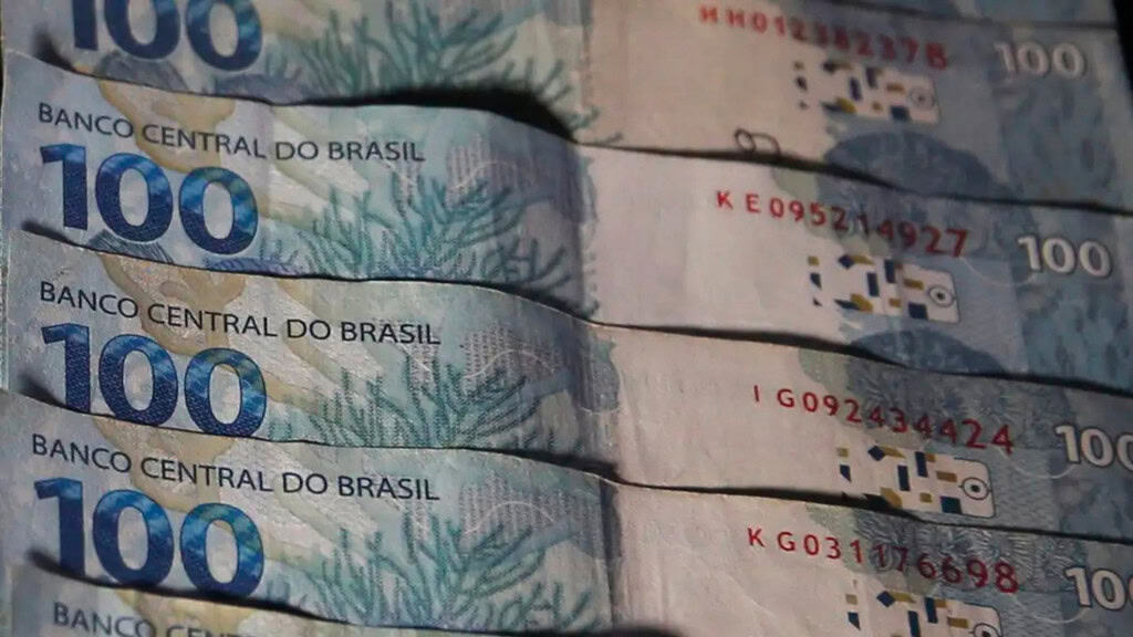 Notas de cem reais colocadas uma em cima da outra