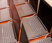 imagem mostra vários computadores notebooks espalhados em uma mesa