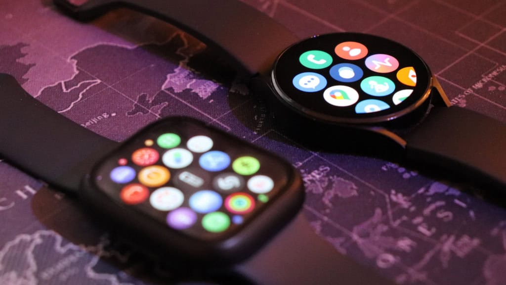 Apple Watch e Galaxy Watch, da Samsung, em cima de uma mesa com estampa de mapa múndi