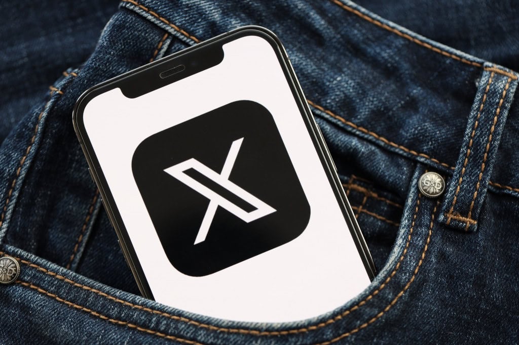 Logo do X em um smartphone dentro do bolso de uma calça jeans