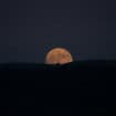 Lua laranja subindo no horizonte