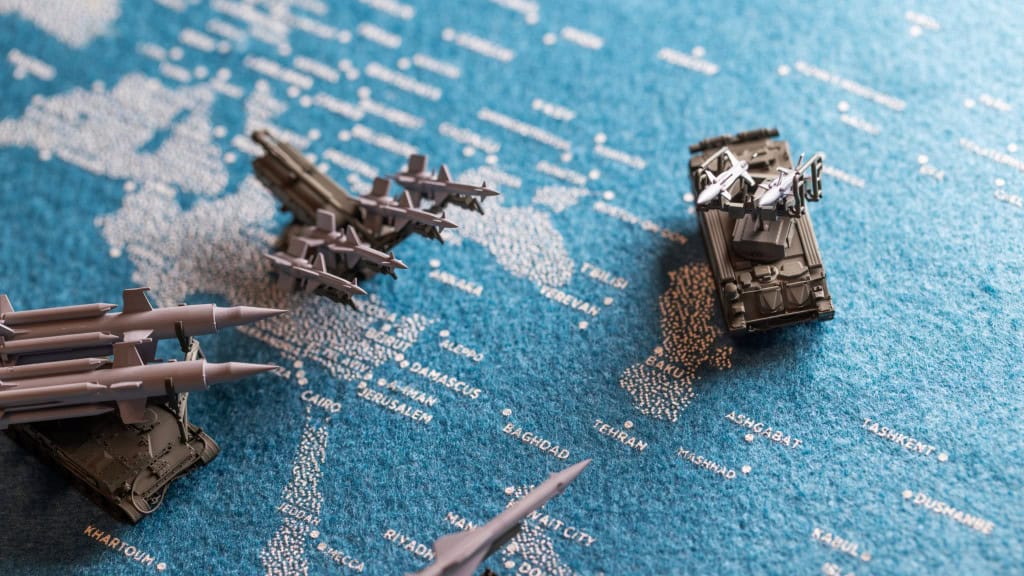 Tanques de guerra de brinquedo em cima de mapa do Oriente Médio