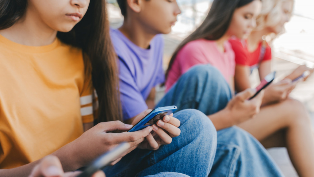 Jovens adolecentes mexendo em celulares