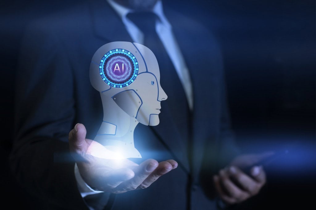 Figura de um homem de terno, sem mostrar a cabeça, com um desenho de uma cabeça de robô em cima de sua mão