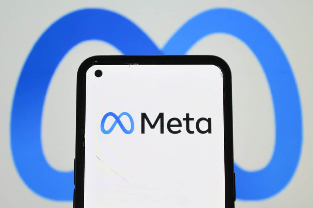 Ao fundo, logo da Meta; à frente o mesmo logo em um smartphone
