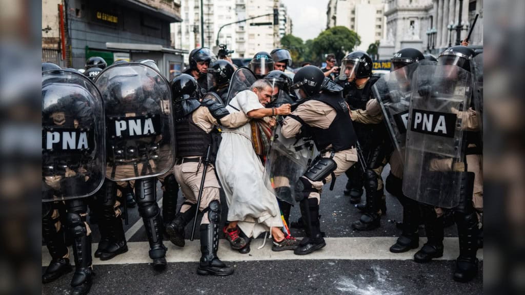 Polícia repreendendo padre idoso durante manifestação na Argentina