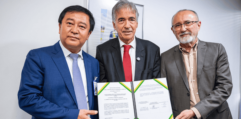 Três representantes dos envolvidos segurando um documento