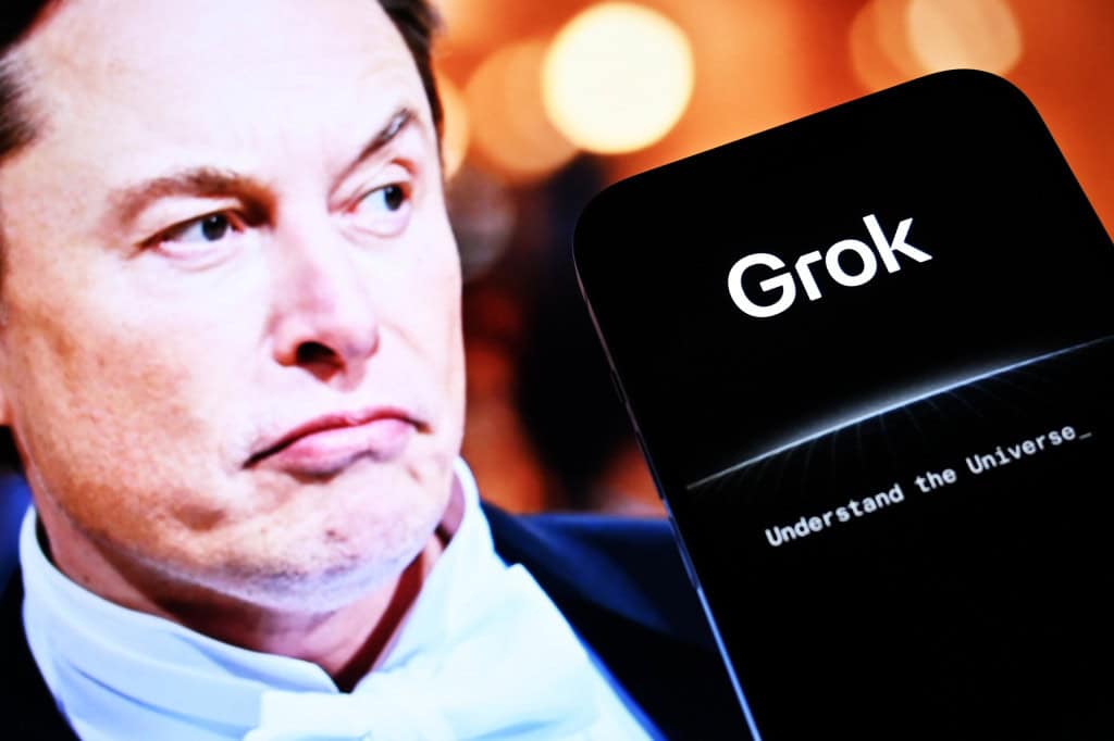 Elon Musk ao lado de um smartphone com o logo do Grok